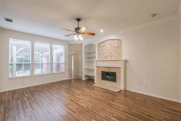 a view of an empty room with a window and wooden floor