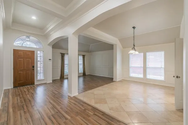 a view of an empty room with window and wooden floor