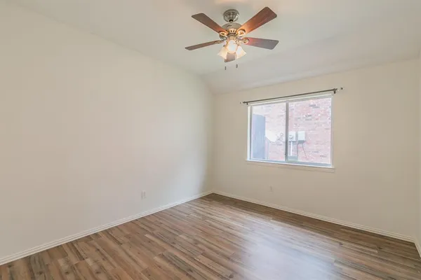 an empty room with a window and a ceiling fan