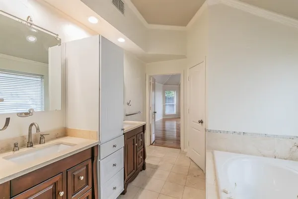 a spacious bathroom with a granite countertop sink mirror and a bathtub