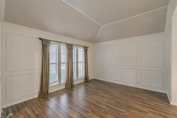 an empty room with wooden floor and sliding door