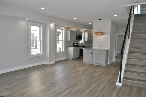 a view of a kitchen with furniture and wooden floor
