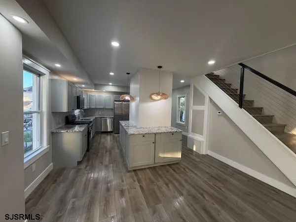 a kitchen with stainless steel appliances granite countertop a sink a stove and a refrigerator