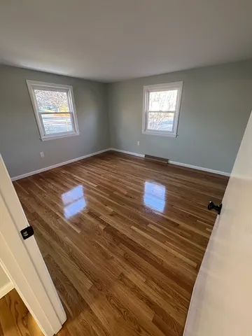 a view of empty room with window and ceiling fan