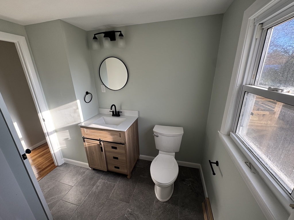 8 Nicks Rock Road, Unit 1 Plymouth, MA 02360 - Photo 18 of 27 a bathroom with a toilet sink and mirror