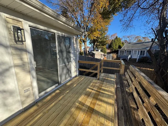 a view of a balcony with chairs and wooden fence