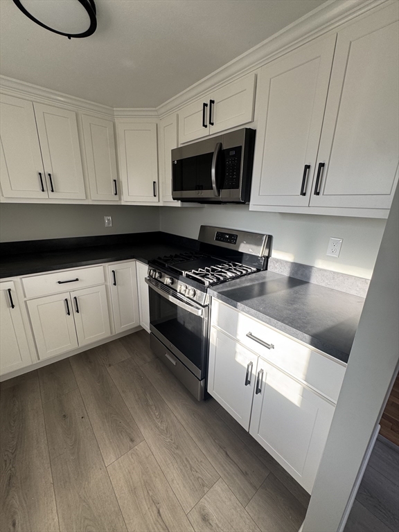 8 Nicks Rock Road, Unit 1 Plymouth, MA 02360 - Photo 9 of 27 a kitchen with granite countertop white cabinets and white appliances