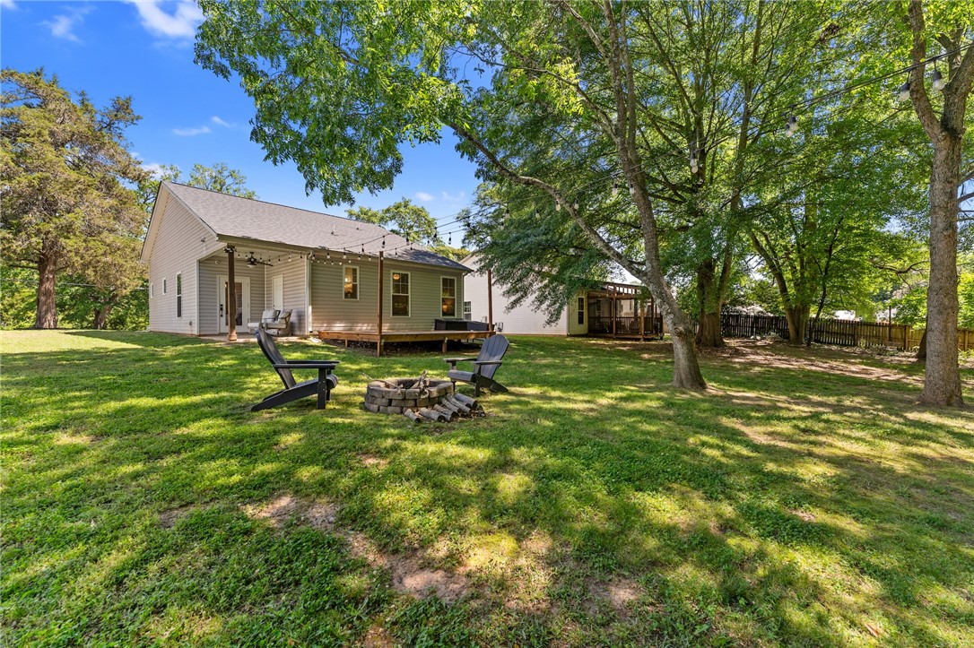 47 A Main Street Pelzer, SC 29669 - Photo 26 of 27 Enjoy outdoor gatherings around the fire pit in this spacious backyard.