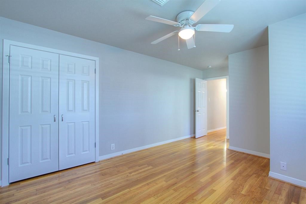 5611 Arboles Drive Houston, TX 77035 - Photo 13 of 13 an empty room with wooden floor fan and windows