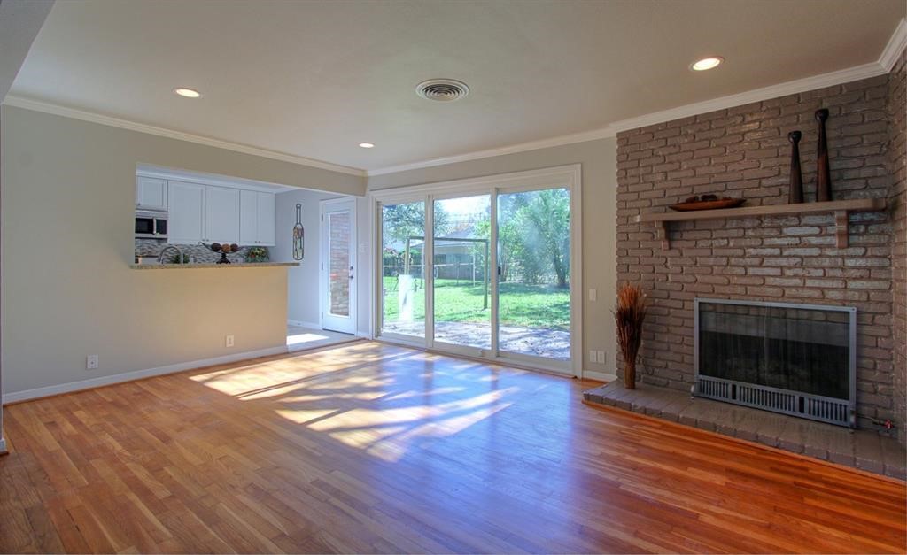 5611 Arboles Drive Houston, TX 77035 - Photo 2 of 13 a view of empty room with wooden floor and fireplace