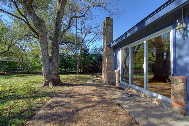 a view of a house with backyard and a tree