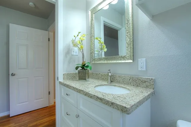 a bathroom with a granite countertop sink and a mirror