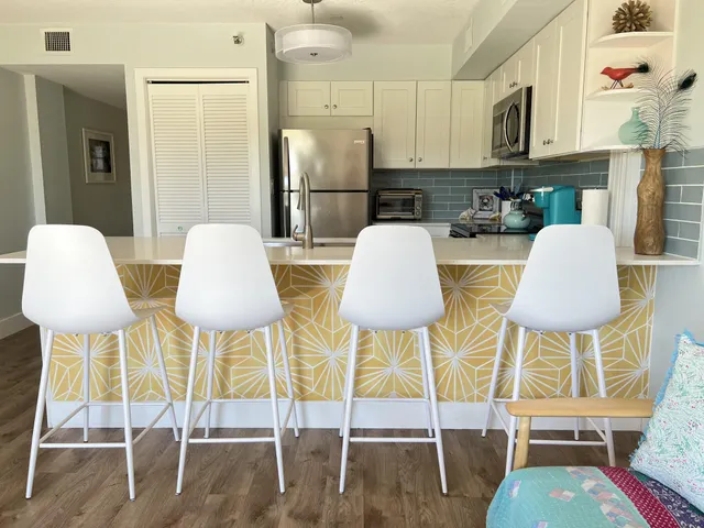 a kitchen with stainless steel appliances a table and chairs in it