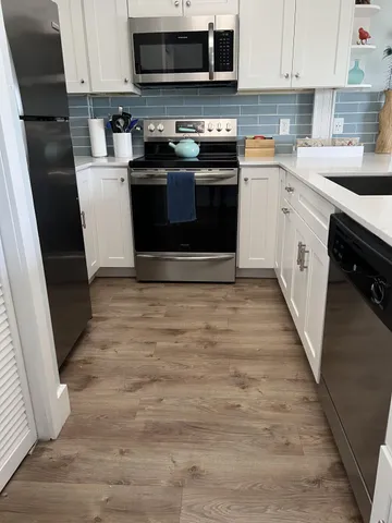 a kitchen with a sink a stove top oven a refrigerator and cabinets