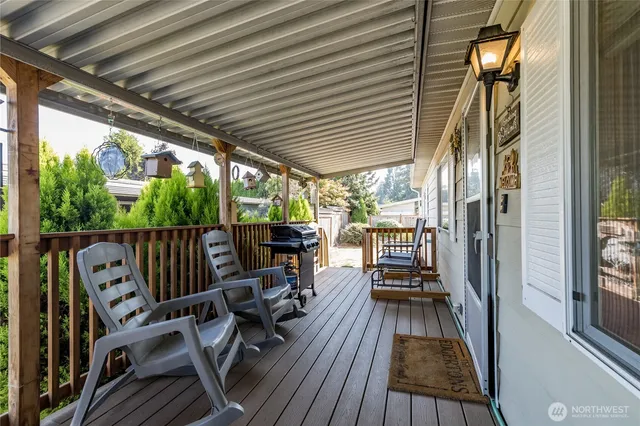 a view of a balcony with chairs and wooden floor