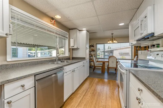 a kitchen with stainless steel appliances granite countertop lots of counter space and a sink