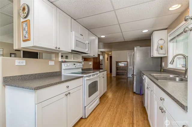a kitchen with stainless steel appliances granite countertop a sink a stove and cabinets