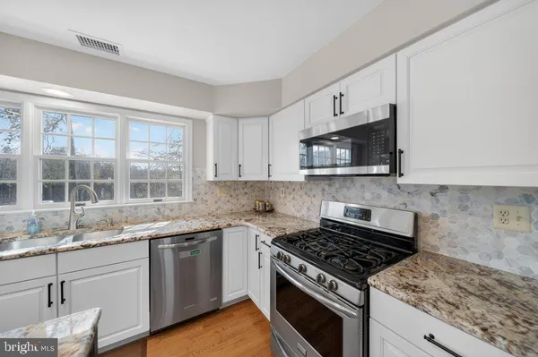 a kitchen with granite countertop a sink and a stove top oven