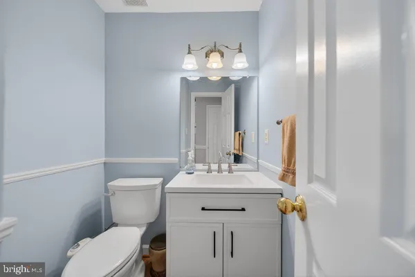 a bathroom with a sink mirror vanity and toilet