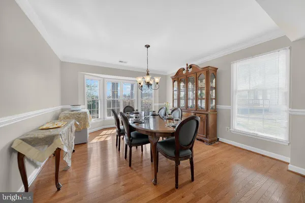 a dining room with furniture window and wooden floor