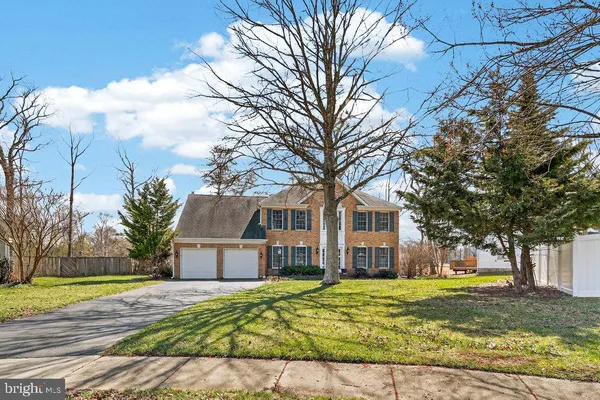 a front view of a house with a yard and trees