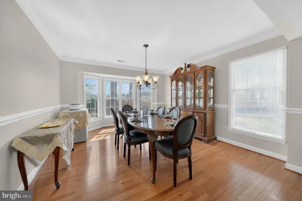 a dining room with furniture window and wooden floor