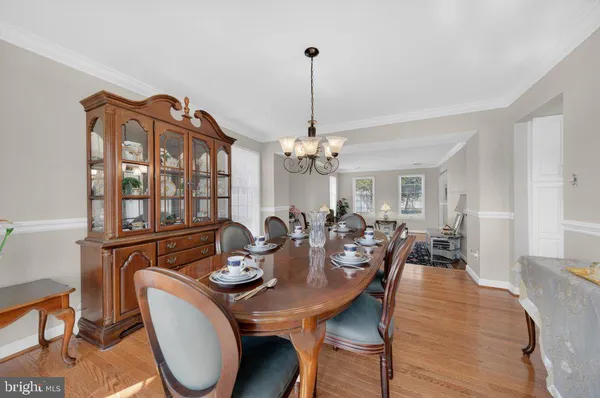 a view of a dining room with furniture a chandelier and wooden floor