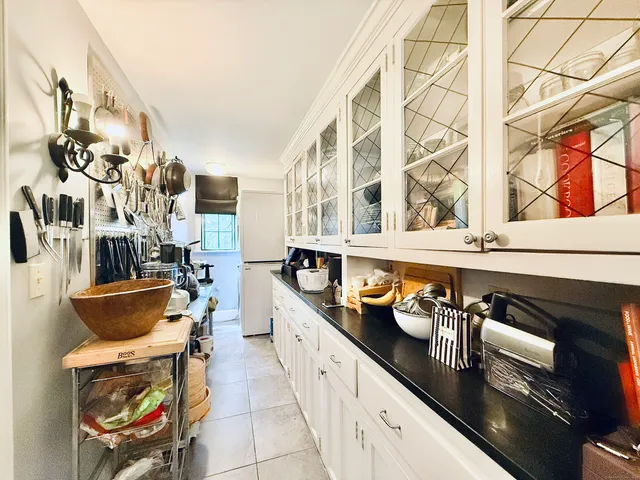 a large white kitchen with stainless steel appliances granite countertop a stove and a sink