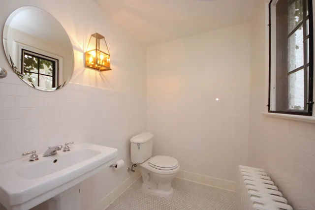 a bathroom with a toilet a sink and mirror