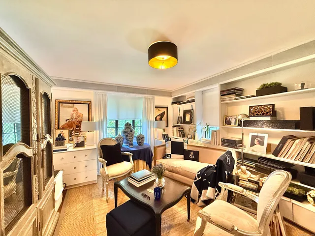 a living room with fireplace furniture and a large window