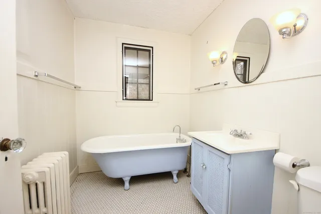 a bathroom with a tub sink and mirror