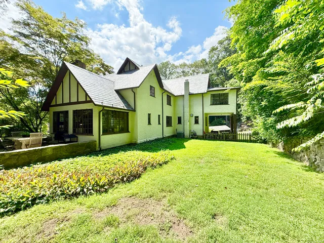 a front view of a house with a garden and yard