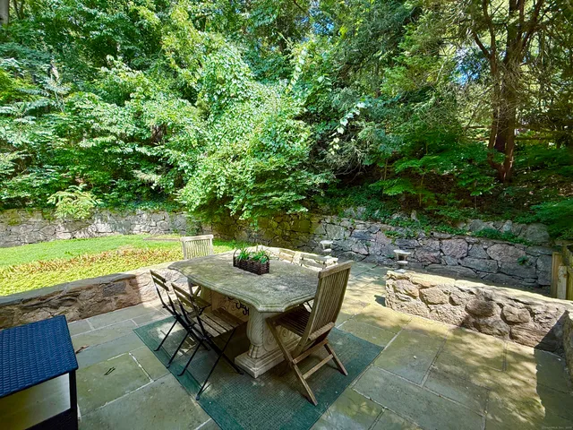 a view of backyard with seating area and trees around