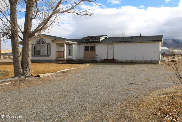 a view of a house with backyard and a tree