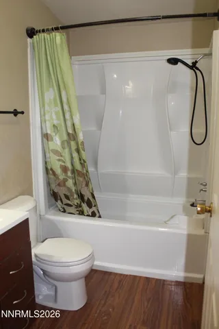 a bathroom with a granite countertop shower a toilet and a sink