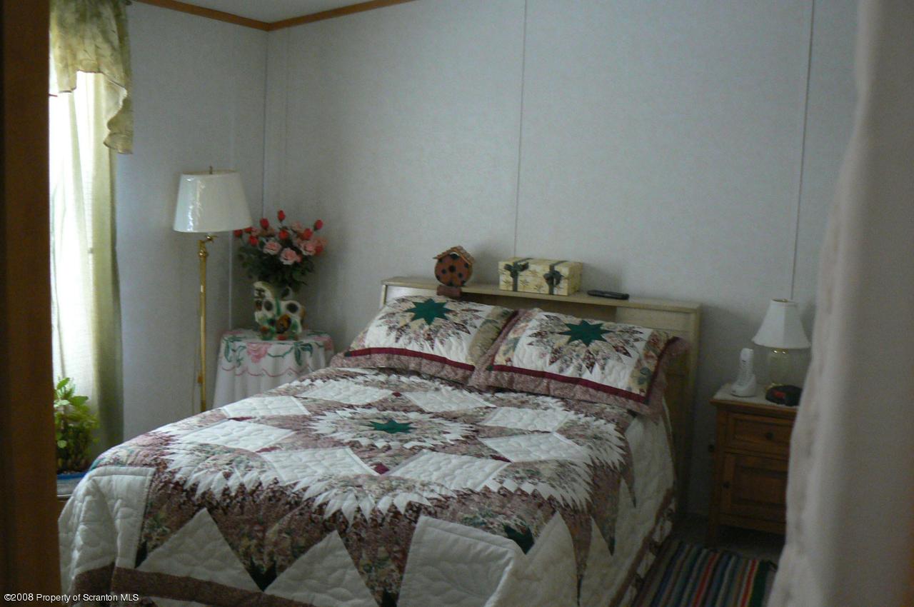 85 Stove Pipe Road Waymart, PA 18472 - Photo 18 of 21 a bed sitting in a bedroom next to a window