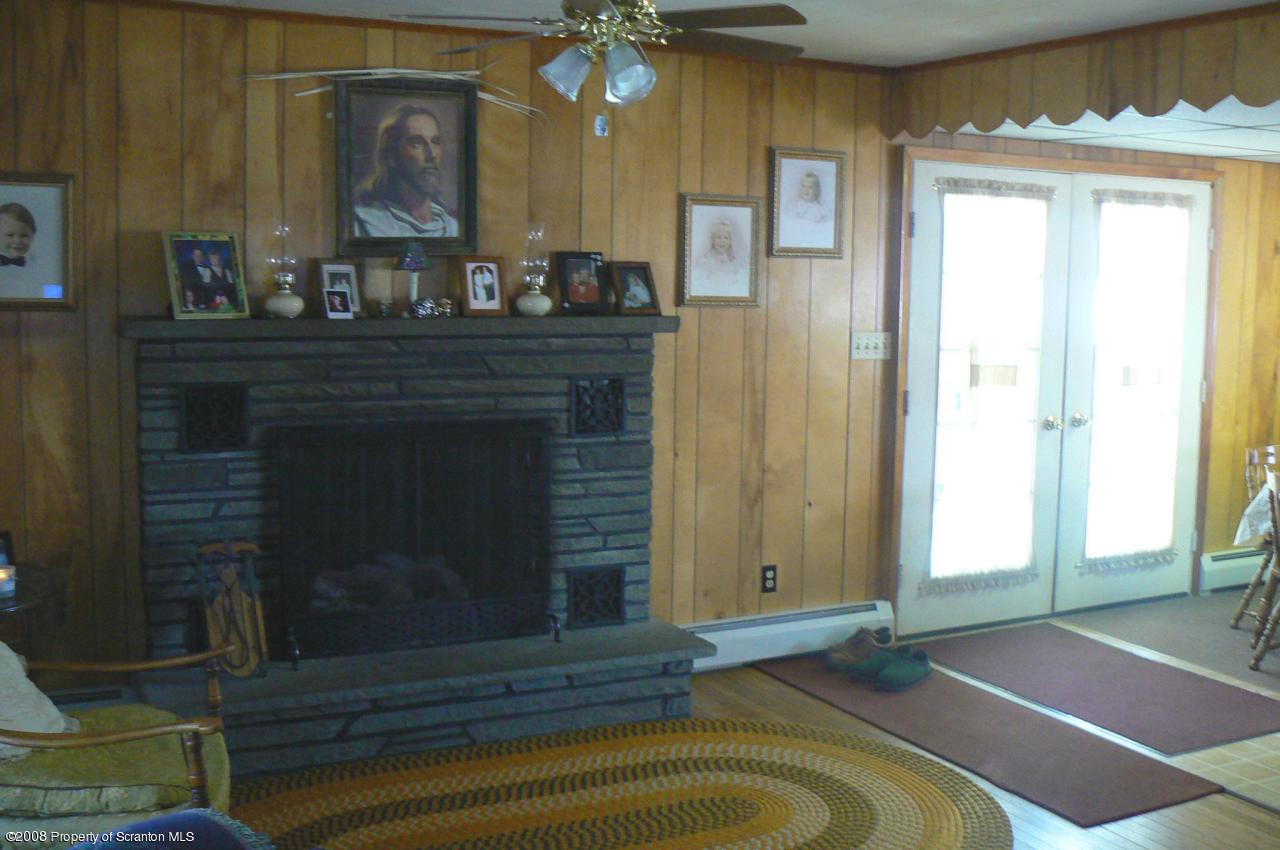 85 Stove Pipe Road Waymart, PA 18472 - Photo 4 of 21 a living room with a fireplace windows and a wooden floor