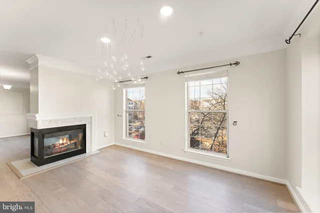 a view of an empty room with a fireplace and a window