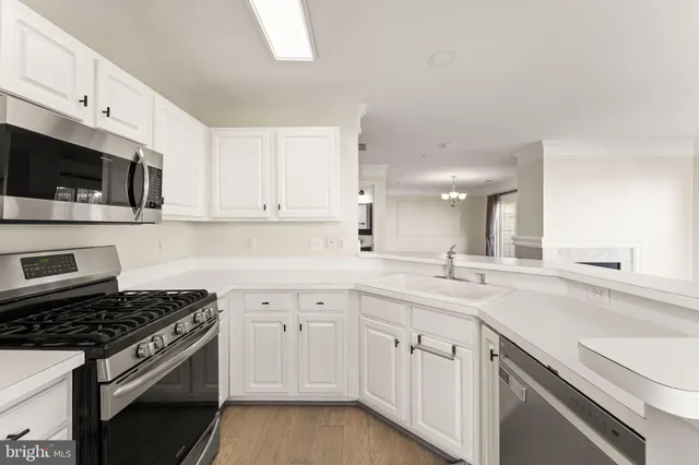 a kitchen with white cabinets and appliances