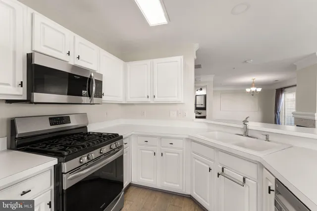 a kitchen with white cabinets and appliances