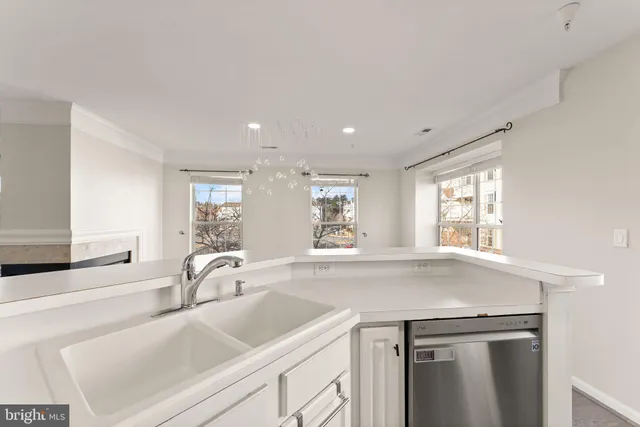 a view with a sink and cabinets with wooden floor