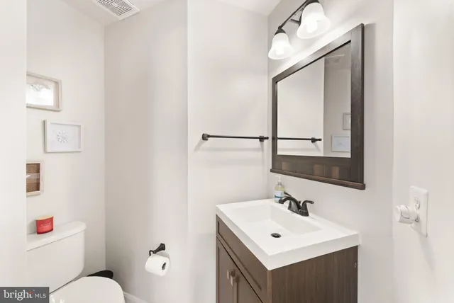 a bathroom with a sink vanity mirror and toilet