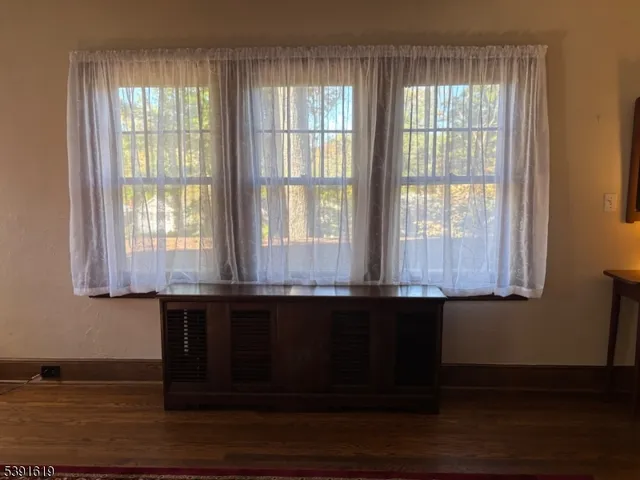 a large kitchen with granite countertop a sink dishwasher a dining table and chairs with wooden floor