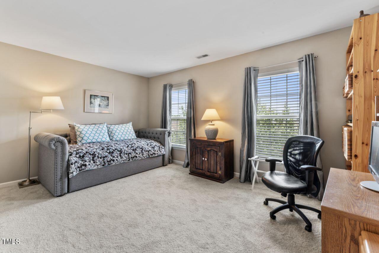 4522 Shady Side Lane Durham, NC 27713 - Photo 11 of 28 a bedroom with a bed a chair and a chandelier