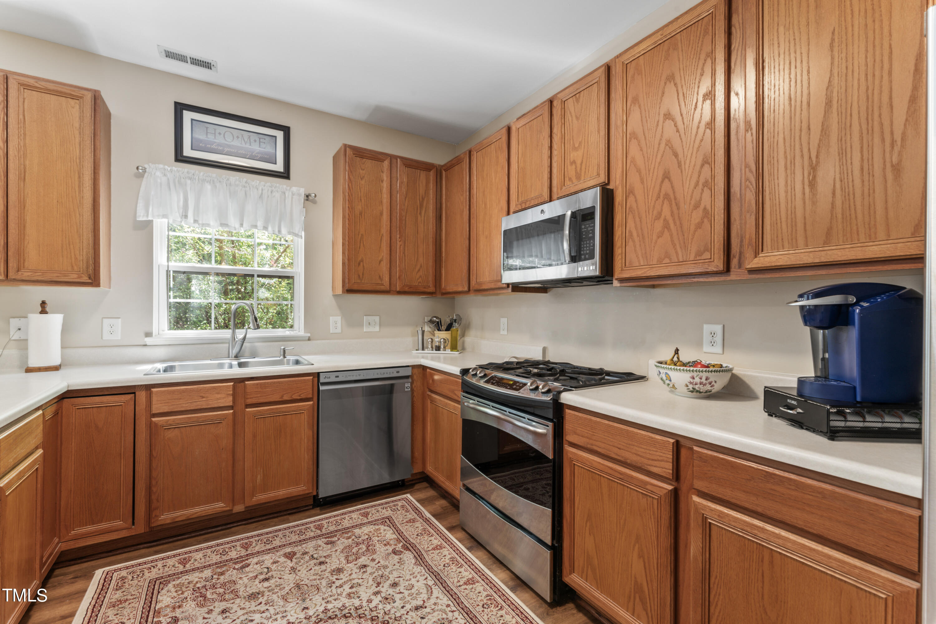 4522 Shady Side Lane Durham, NC 27713 - Photo 21 of 28 a kitchen with stainless steel appliances granite countertop wooden cabinets a sink and a stove