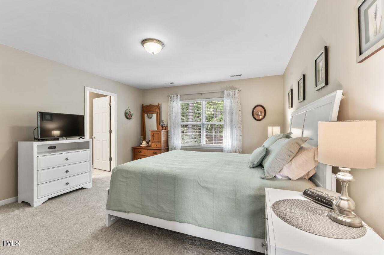 4522 Shady Side Lane Durham, NC 27713 - Photo 23 of 28 a bedroom with a bed and flat screen tv