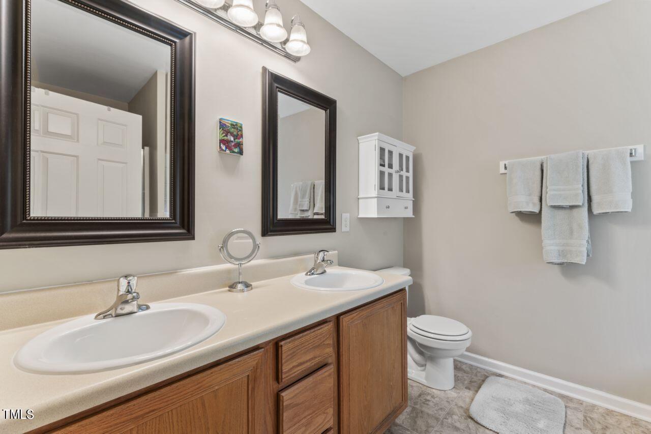 4522 Shady Side Lane Durham, NC 27713 - Photo 24 of 28 a bathroom with a toilet sink and mirror