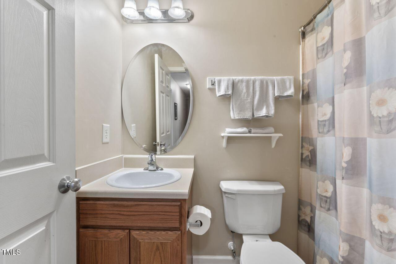 4522 Shady Side Lane Durham, NC 27713 - Photo 25 of 28 a bathroom with a toilet sink and mirror