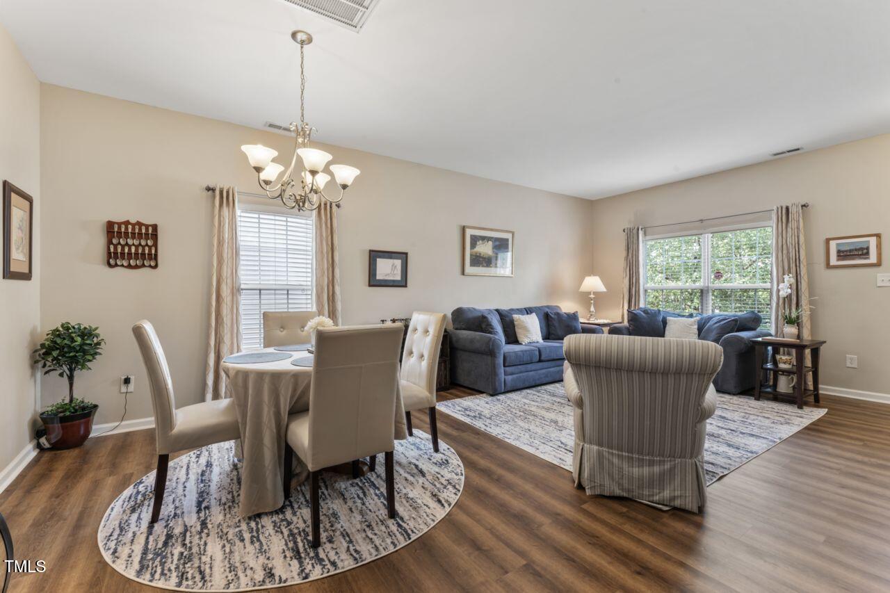 4522 Shady Side Lane Durham, NC 27713 - Photo 4 of 28 a dining room with furniture a rug a potted plant and wooden floor
