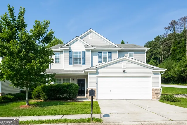 a front view of a house with a yard and trees